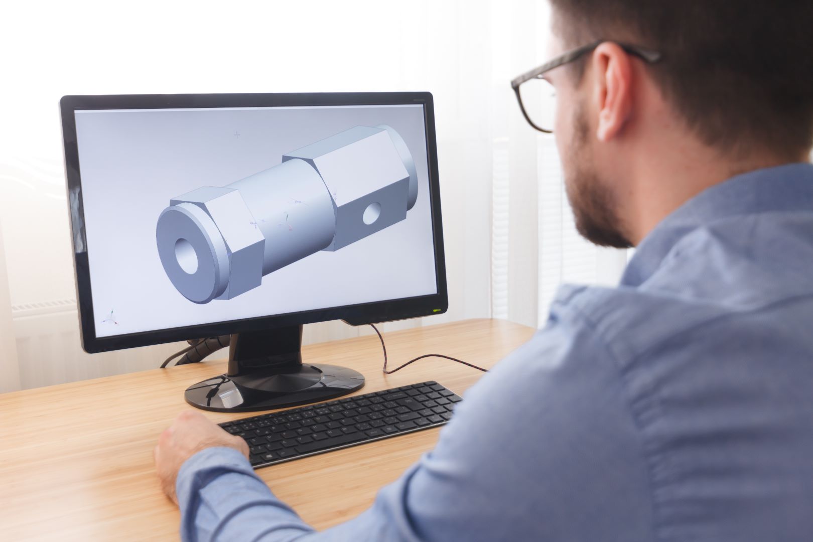 Engineer, Constructor, Designer in Glasses Working on a Personal Computer. He is Creating, Designing a New 3D Model of Mechanical Component in CAD Program. Freelance Work, LOS ANGELES, CALIFORNIA – 25.10.2019.